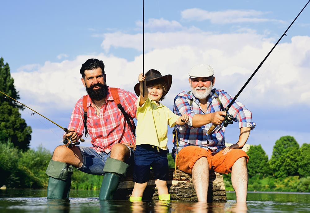 A young boy fishing with his dad and granddad.